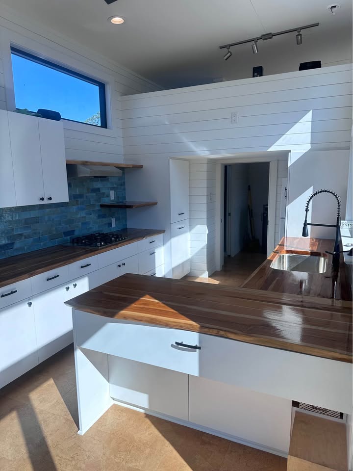 Tiny house kitchen with wood countertops and blue tile backsplash